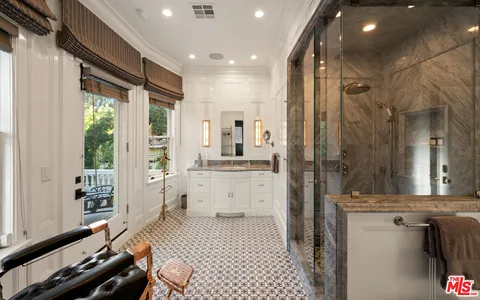 a bathroom with a double vanity sink a mirror and a shower