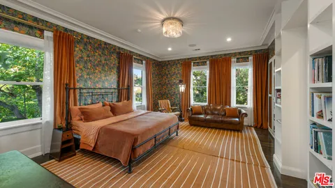 a bedroom with a bed and a large window with balcony view