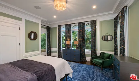 a bedroom with a bed and a chandelier