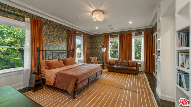 a bedroom with a bed and a large window with balcony view