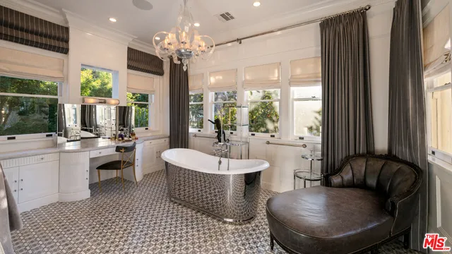 a living room with furniture a large window and a chandelier