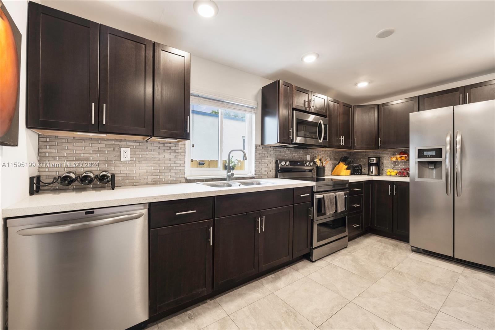 4420 Northwest 3rd Avenue Miami, FL 33127 - Photo 12 of 36 a kitchen with stainless steel appliances granite countertop a refrigerator and a stove top oven