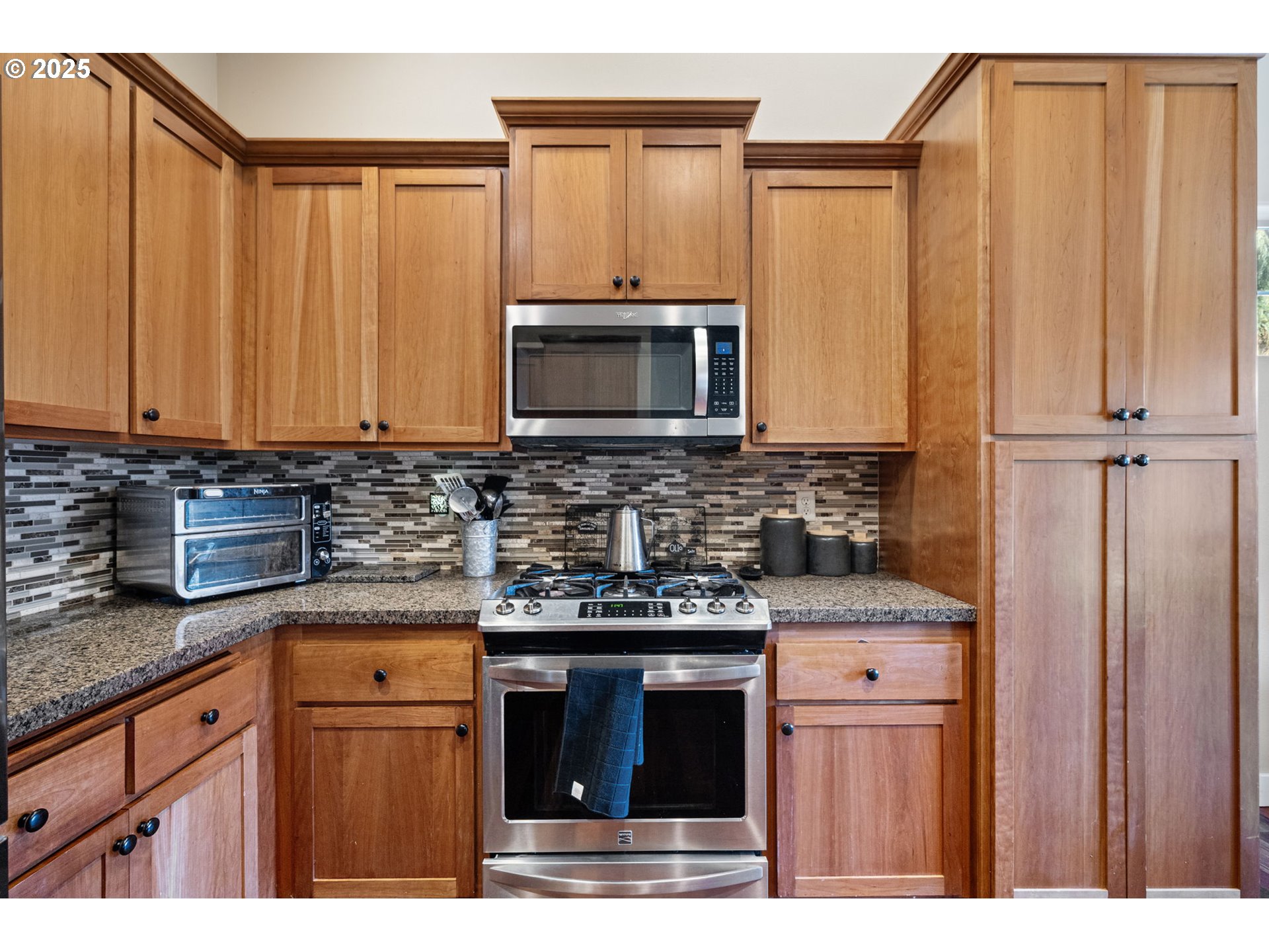 1175 South 40th Place Springfield, OR 97478 - Photo 18 of 34 a kitchen with stainless steel appliances granite countertop a stove a microwave and a sink