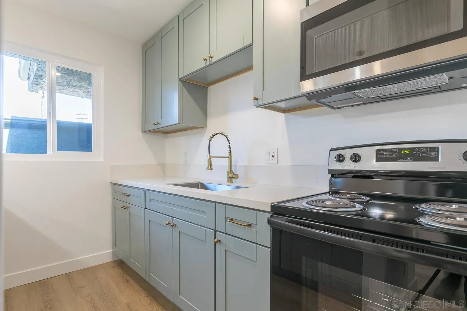 9249 Birch Street Spring Valley, CA 91977 - Photo 9 of 24 a kitchen with stainless steel appliances a stove and white cabinets