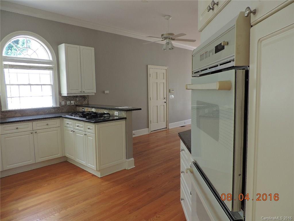 19213 Captains Watch Road Cornelius, NC 28031 - Photo 4 of 23 a kitchen with granite countertop a refrigerator a sink and wooden floor