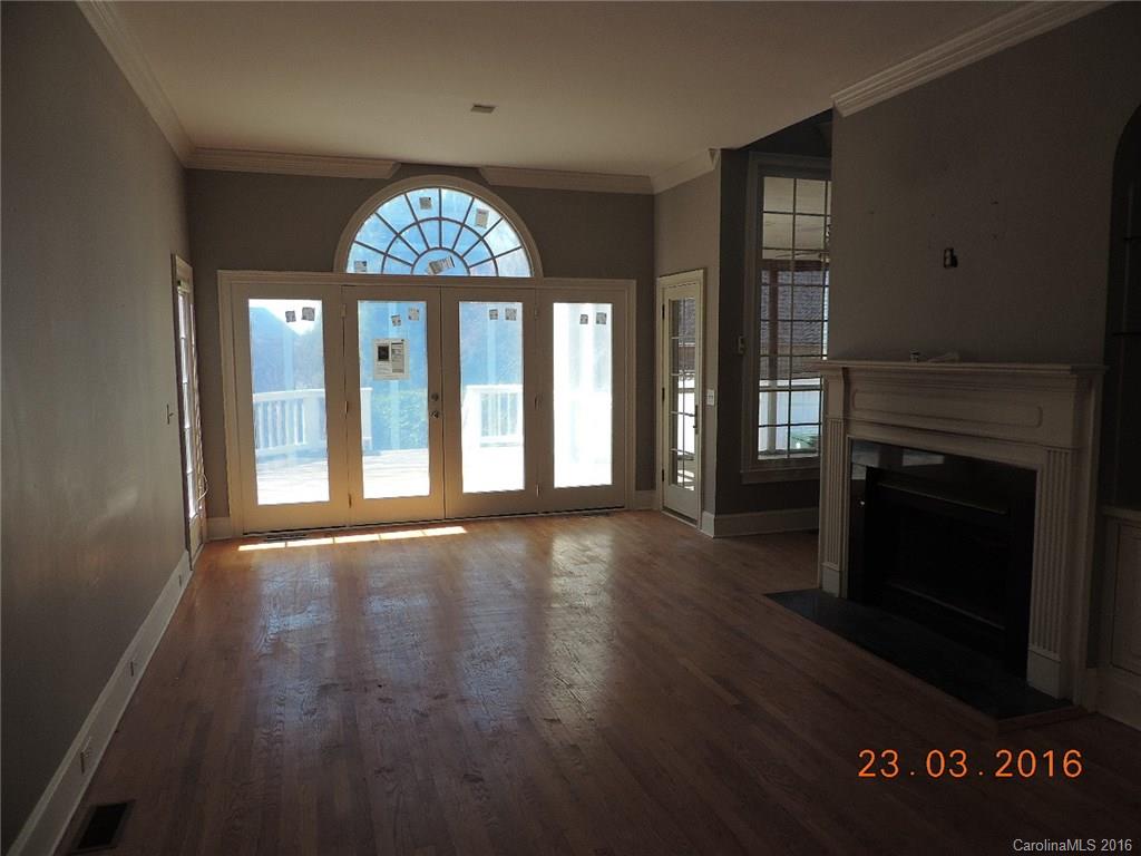19213 Captains Watch Road Cornelius, NC 28031 - Photo 6 of 23 an empty room with wooden floor a fireplace and windows