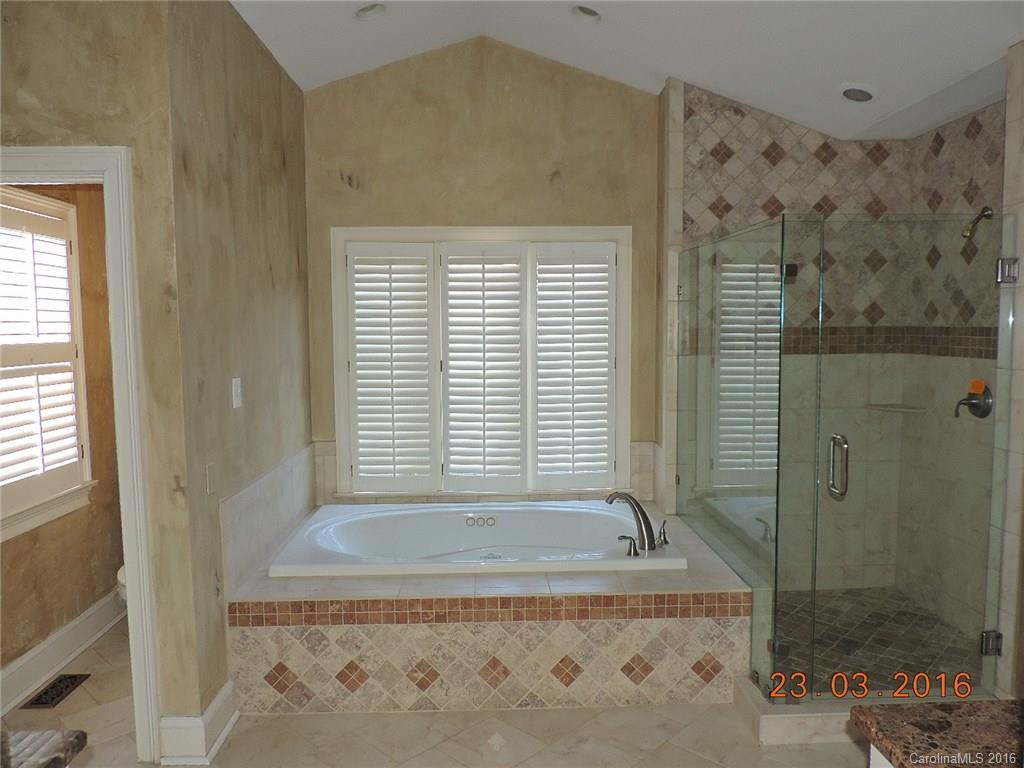 19213 Captains Watch Road Cornelius, NC 28031 - Photo 10 of 23 a bathroom with a granite countertop bathtub and shower