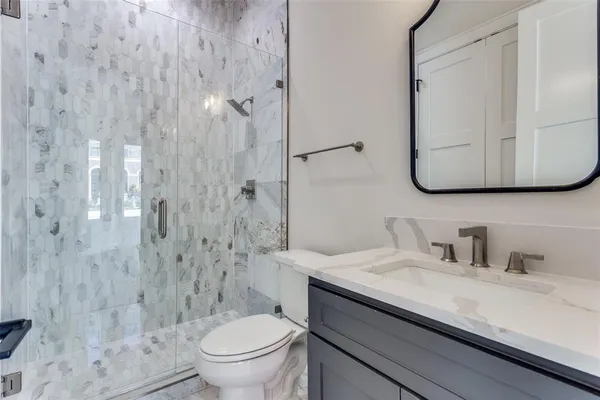 a bathroom with a granite countertop sink a toilet and a mirror