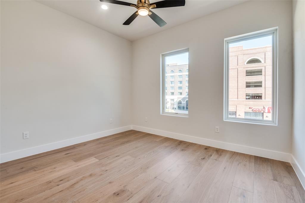 250 East Dallas Road, Unit 112 Grapevine, TX 76051 - Photo 21 of 33 an empty room with wooden floor and windows
