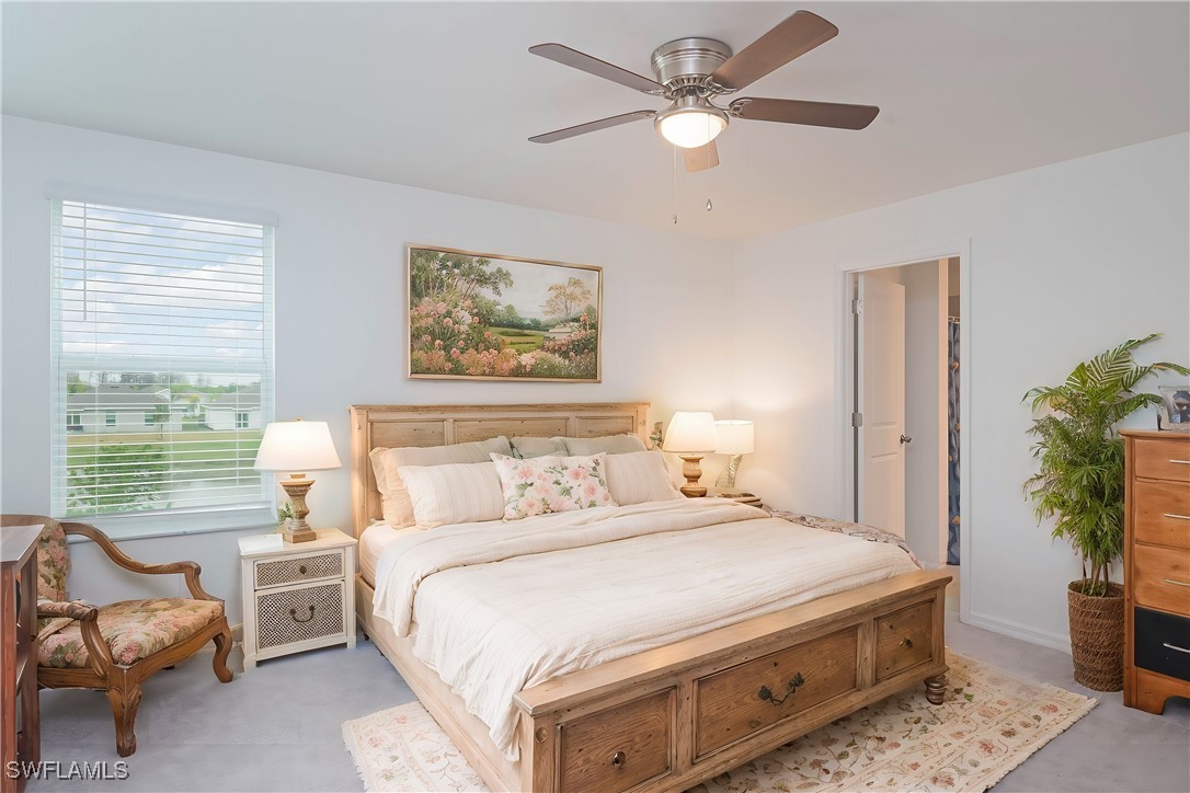 12310 Dakota Ridge Place Lehigh Acres, FL 33974 - Photo 17 of 34 a bedroom with a bed chandelier and a window