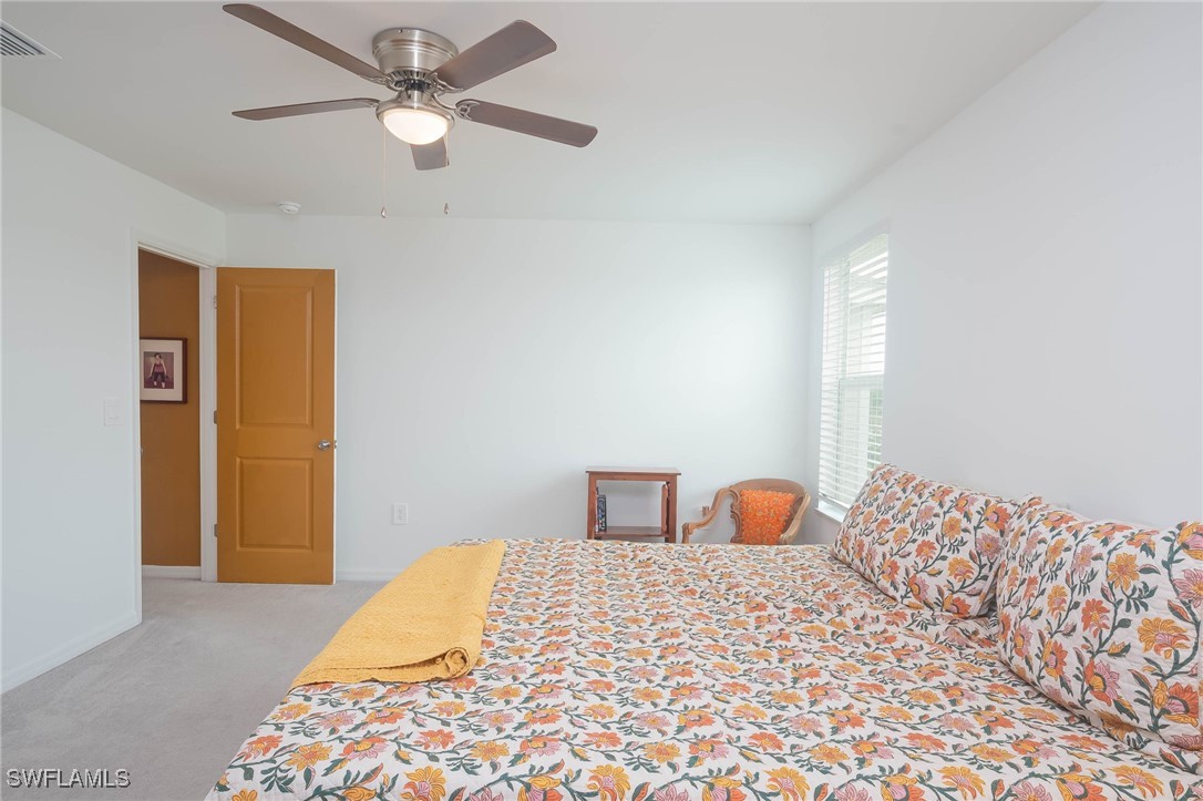 12310 Dakota Ridge Place Lehigh Acres, FL 33974 - Photo 21 of 34 a bedroom with a bed and a chandelier