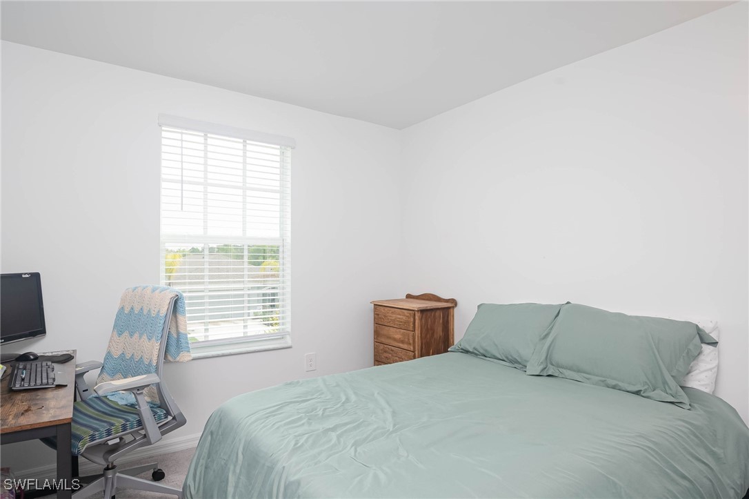 12310 Dakota Ridge Place Lehigh Acres, FL 33974 - Photo 22 of 34 a large bed sitting in a bedroom next to a window