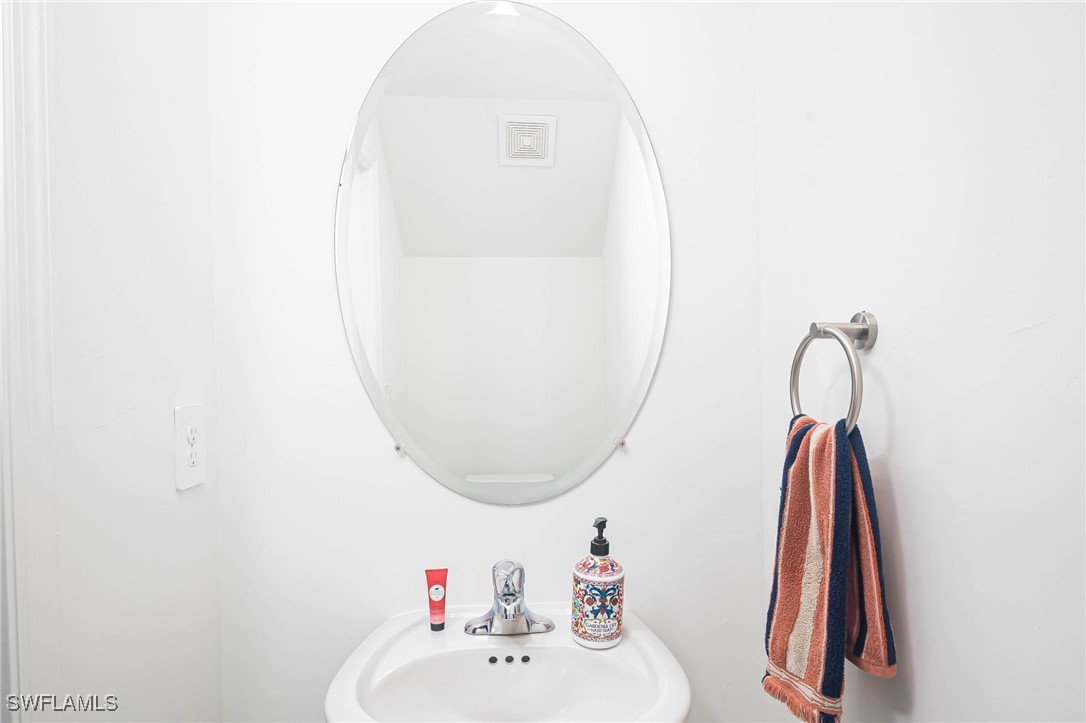 12310 Dakota Ridge Place Lehigh Acres, FL 33974 - Photo 24 of 34 a bathroom with a sink and a mirror
