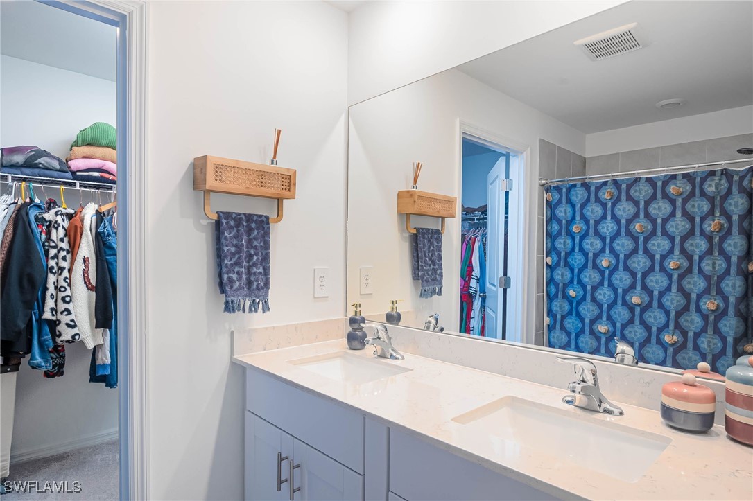 12310 Dakota Ridge Place Lehigh Acres, FL 33974 - Photo 25 of 34 a bathroom with a sink vanity and a mirror
