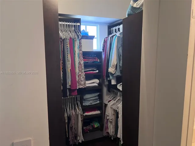 a view of walk in closet with clothes and shoes