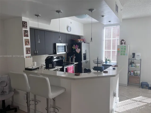 a kitchen with a dining table chairs refrigerator and sink