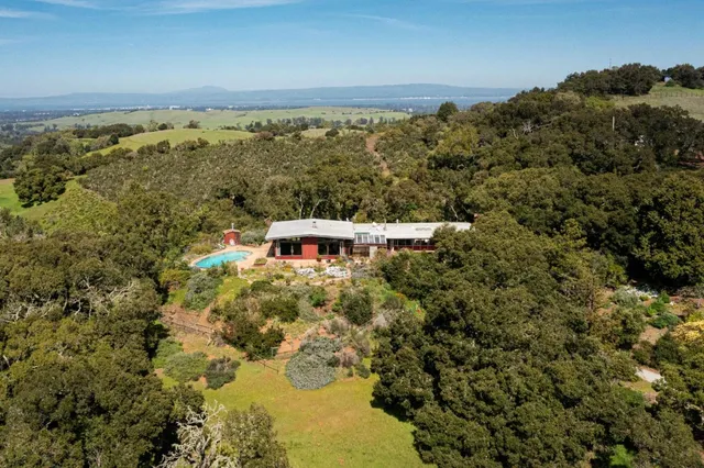 an aerial view of residential houses with outdoor space and trees