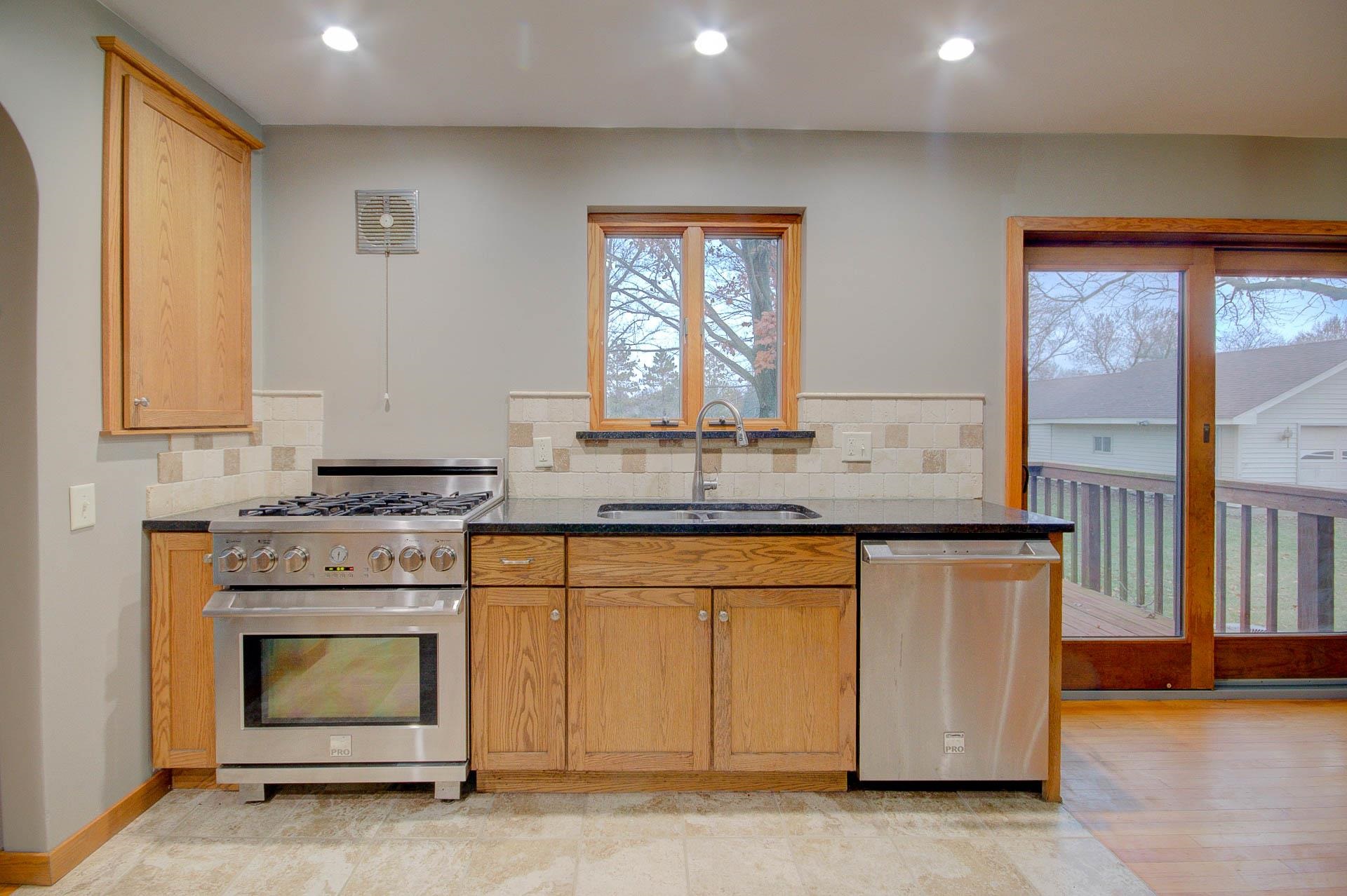 327 4th Street Andover, IL 61233 - Photo 26 of 58 a kitchen with granite countertop a stove a sink and a microwave