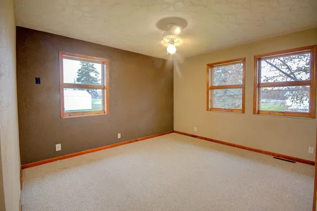 an empty room with windows and closet area