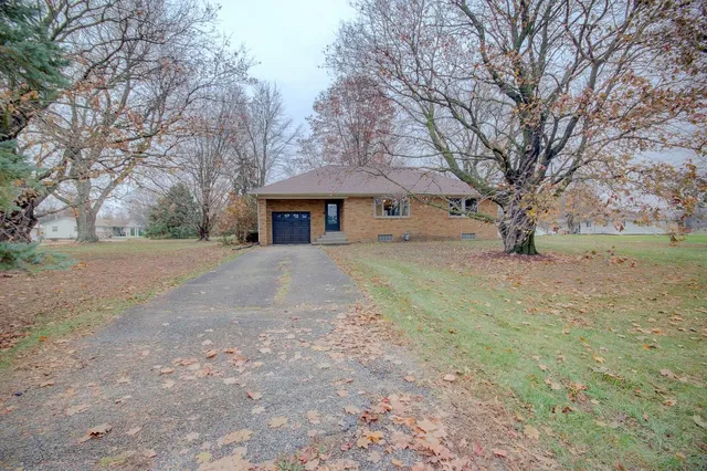 a white house that has a tree on the side of it