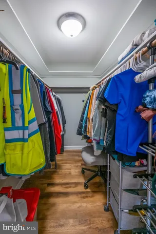a view of walk in closet with clothes and shoes