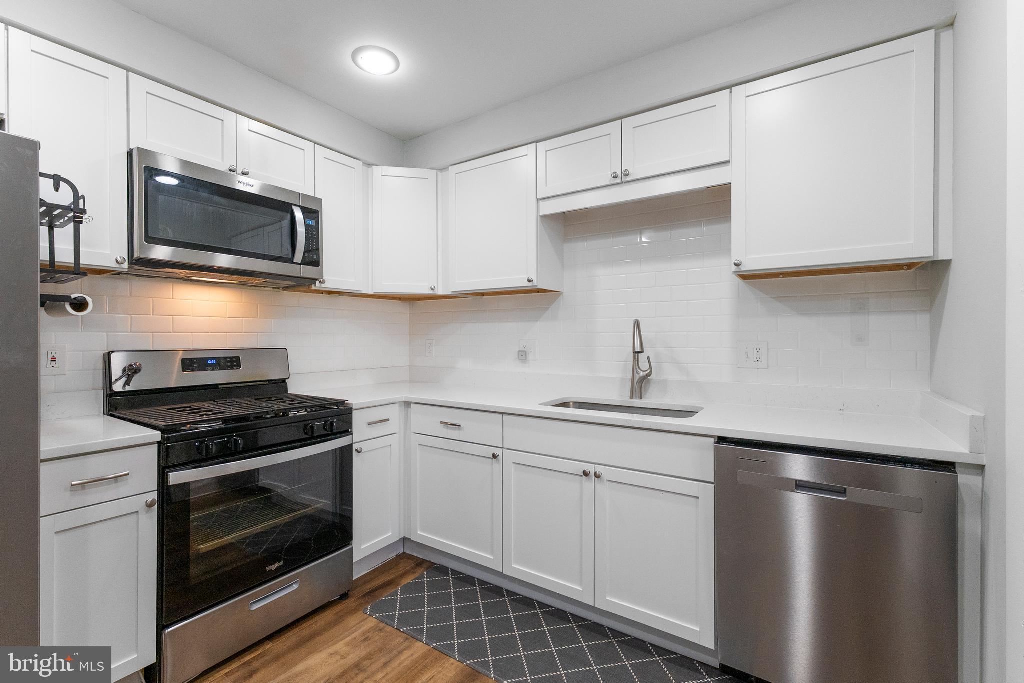 10067 Windstream Drive, Unit 2 Columbia, MD 21044 - Photo 2 of 30 a kitchen with a sink stove and microwave