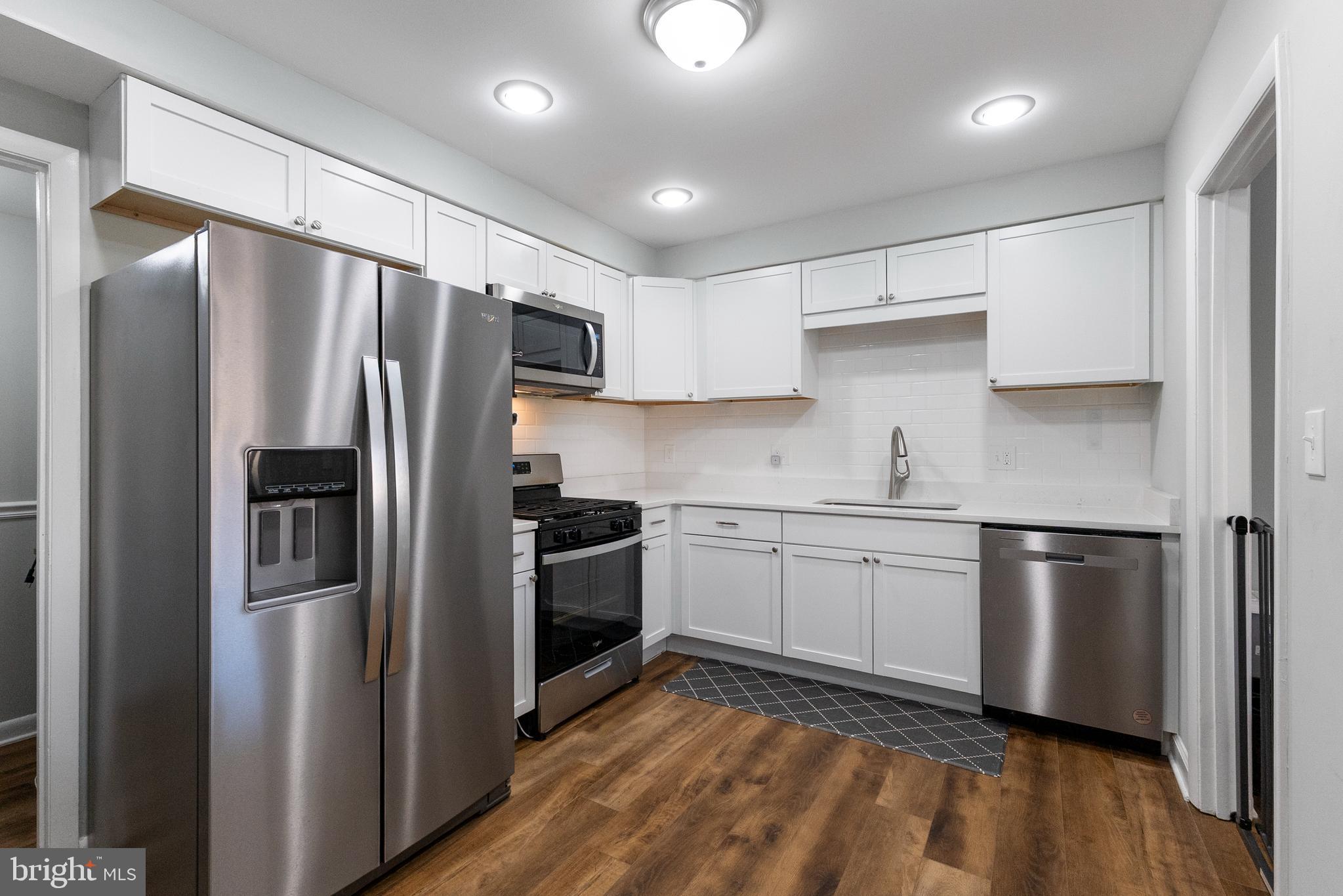 10067 Windstream Drive, Unit 2 Columbia, MD 21044 - Photo 3 of 30 a kitchen with granite countertop stainless steel appliances a refrigerator a sink and white cabinets