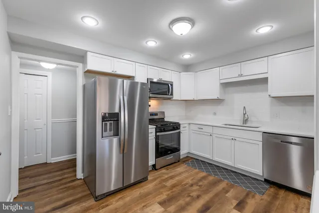 a kitchen with stainless steel appliances granite countertop a refrigerator and a stove top oven