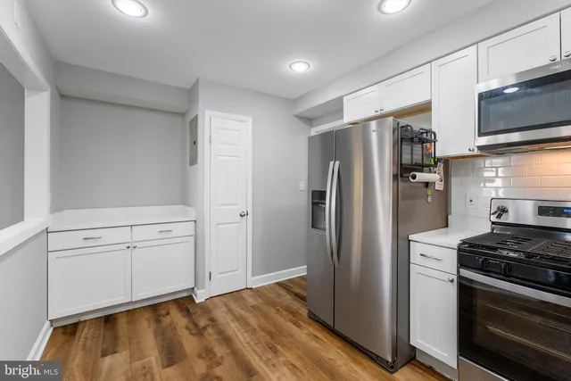 a kitchen with white cabinets and stainless steel appliances