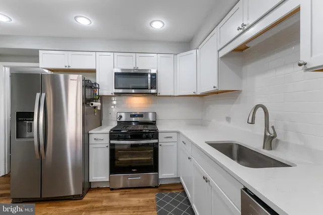 a kitchen with stainless steel appliances a refrigerator stove and sink