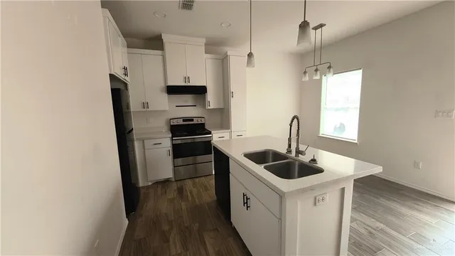 a kitchen with stainless steel appliances granite countertop a sink and a refrigerator
