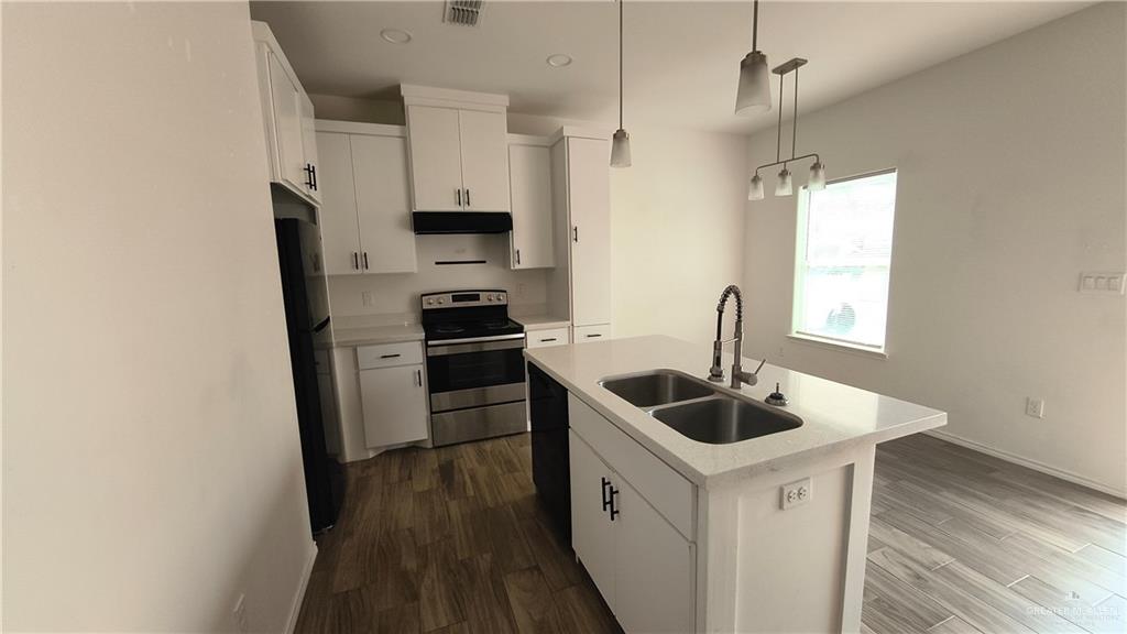 941 South Indiana Avenue, Unit B Mercedes, TX 78570 - Photo 15 of 16 a kitchen with stainless steel appliances granite countertop a sink and a refrigerator