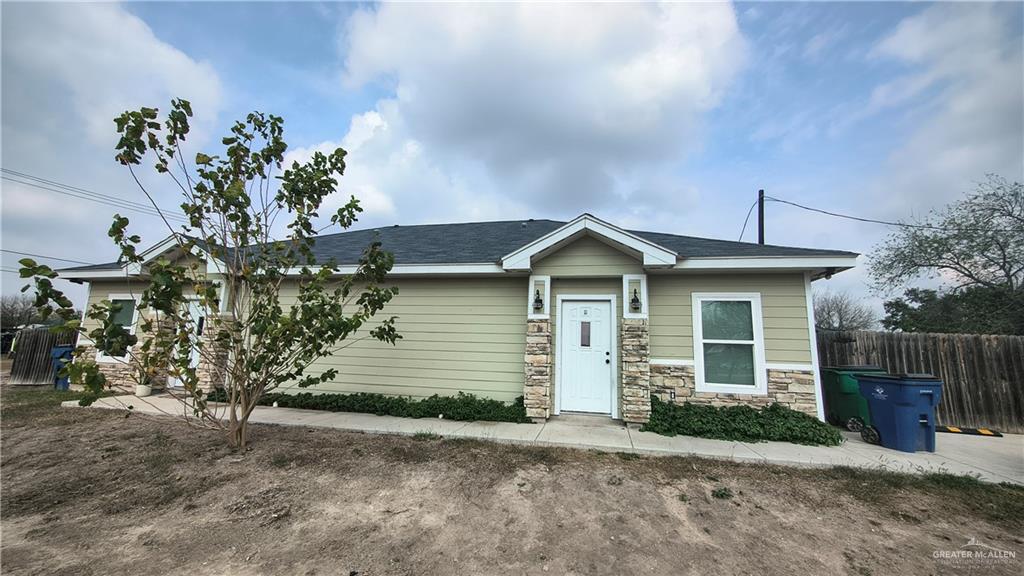 941 South Indiana Avenue, Unit B Mercedes, TX 78570 - Photo 2 of 16 a front view of a house with a yard and garage