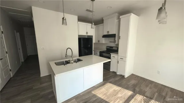 a kitchen with stainless steel appliances a stove a sink and a refrigerator