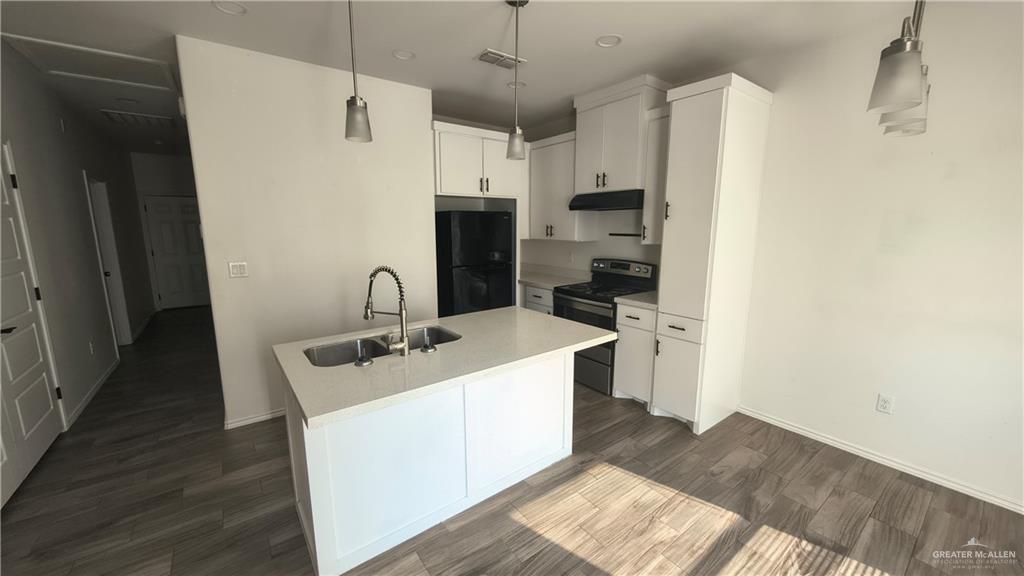 941 South Indiana Avenue, Unit B Mercedes, TX 78570 - Photo 3 of 16 a kitchen with stainless steel appliances a stove a sink and a refrigerator