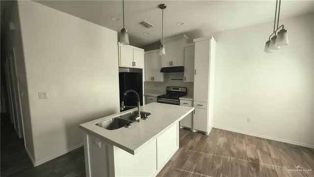 a kitchen with a sink a refrigerator and a stove