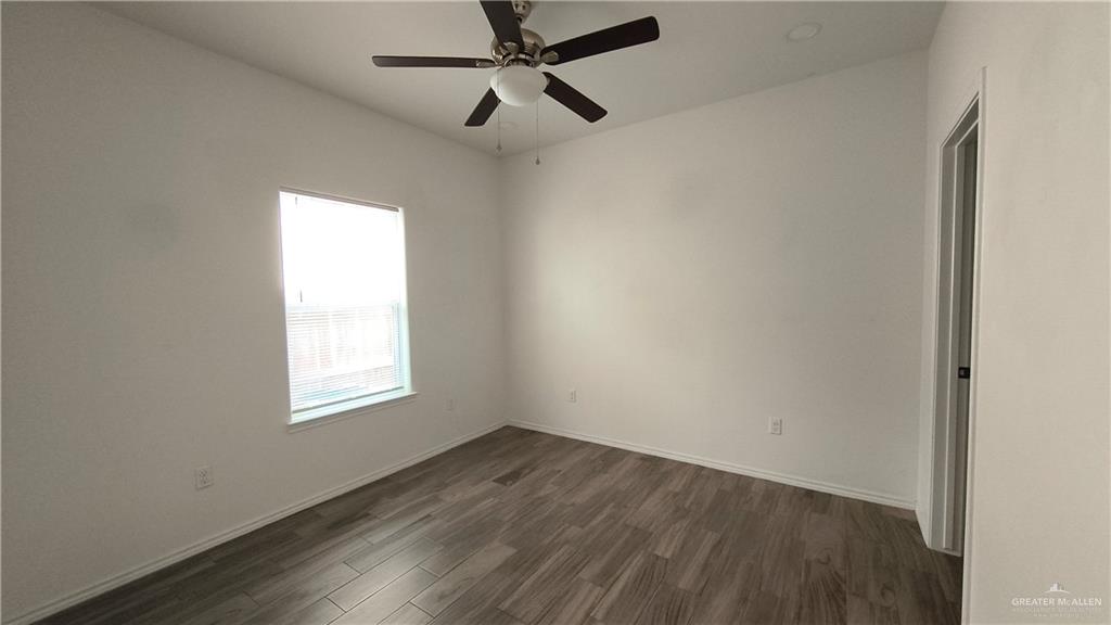 941 South Indiana Avenue, Unit B Mercedes, TX 78570 - Photo 10 of 16 an empty room with wooden floor ceiling fan and windows