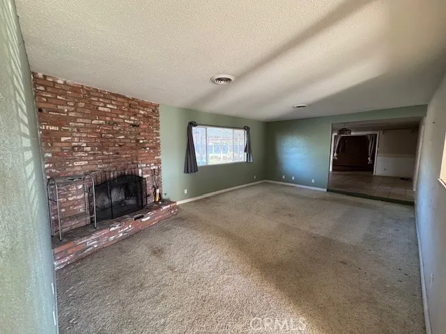an empty room with windows and fireplace