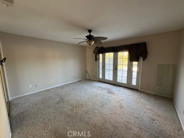 an empty room with a ceiling fan and window