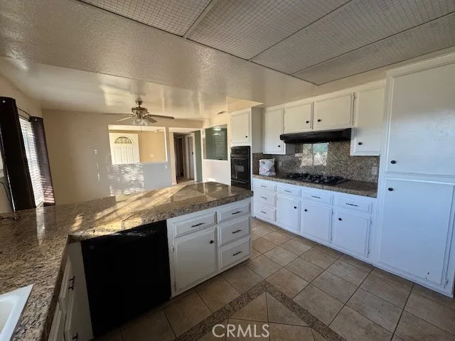 a large kitchen with granite countertop a sink and dishwasher stove a refrigerator with wooden cabinets