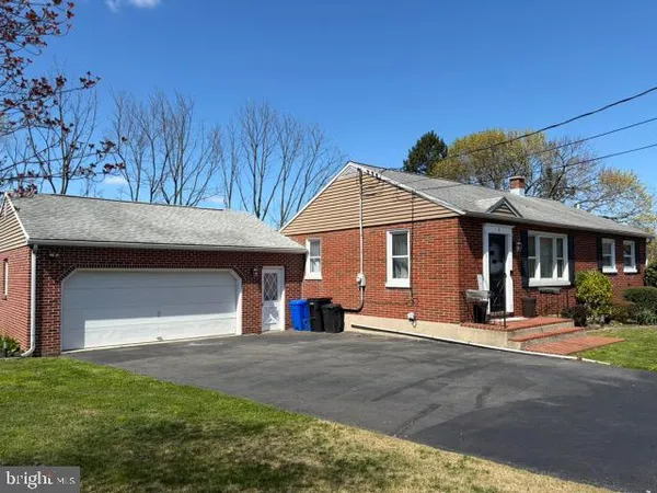 a view of a house with a yard and large tree
