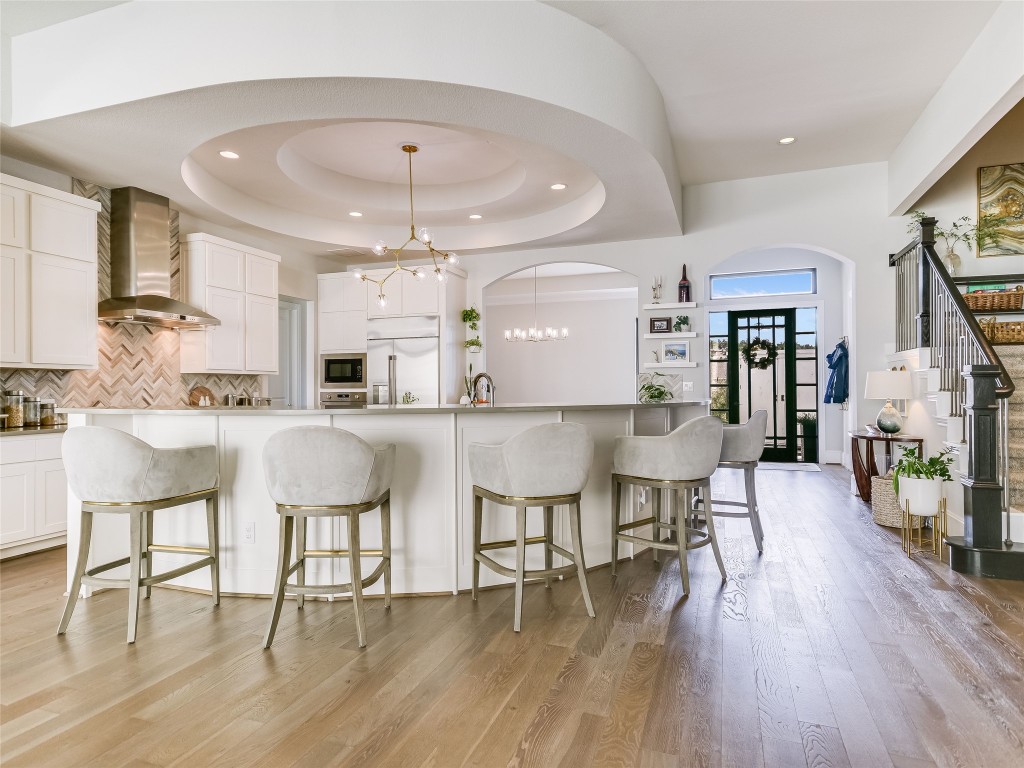 a kitchen with stainless steel appliances kitchen island granite countertop a table chairs and a refrigerator