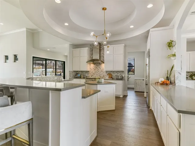 a large kitchen with lots of counter space a sink appliances and living room view