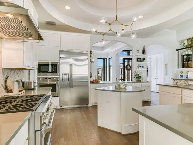 a kitchen with kitchen island a counter space a sink appliances and cabinets