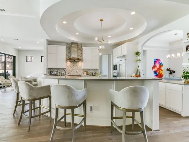 a kitchen with stainless steel appliances granite countertop table chairs stove a sink and dishwasher