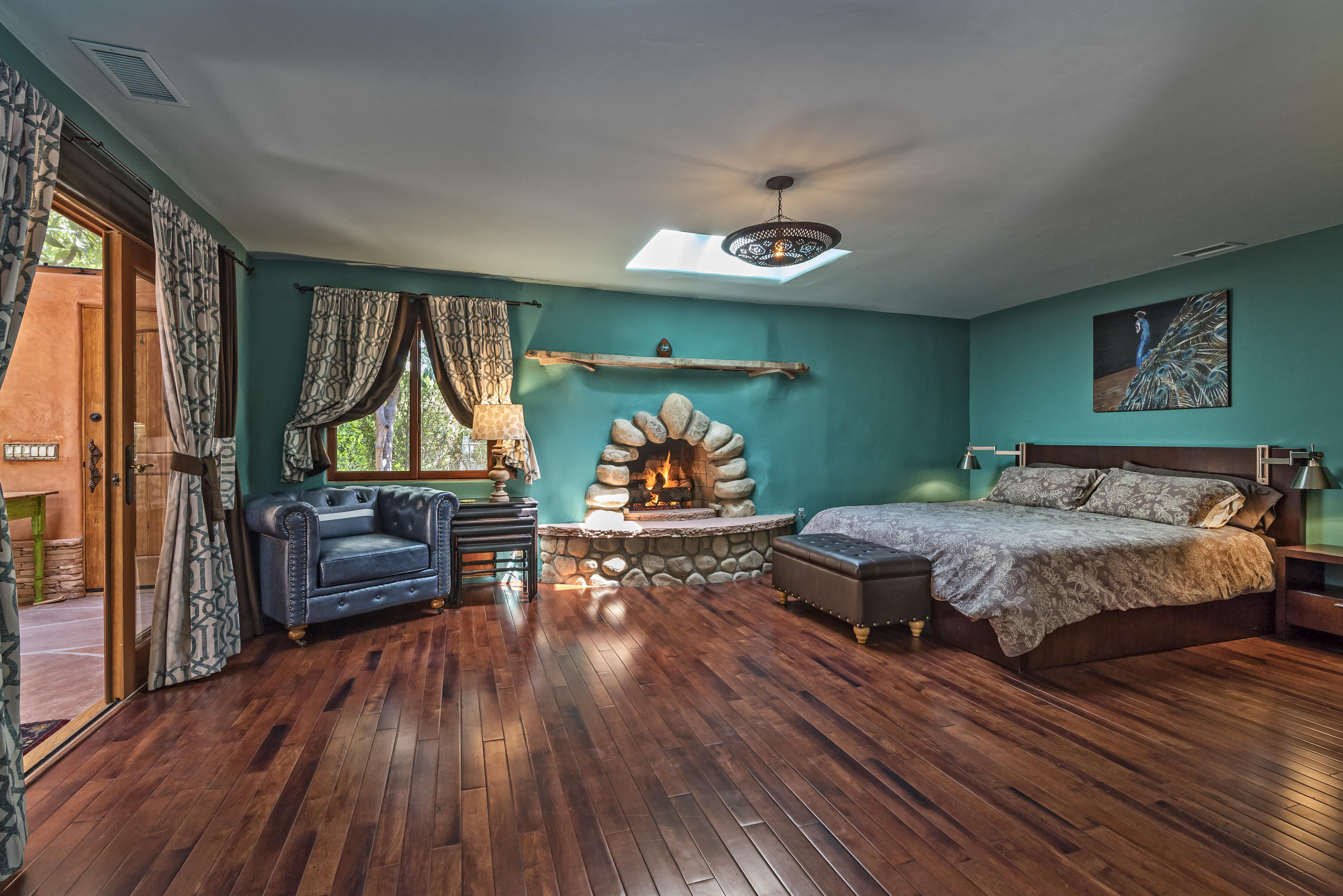 129 Grapevine Road Oak View, CA 93022 - Photo 17 of 24 a bedroom with a bed and a chandelier