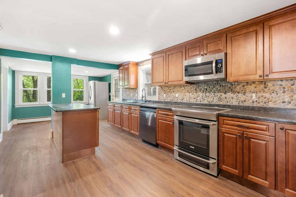 32 Undine Circle Springfield, MA 01109 - Photo 3 of 38 a kitchen with stainless steel appliances granite countertop wooden cabinets a stove top oven a sink and dishwasher with wooden floor