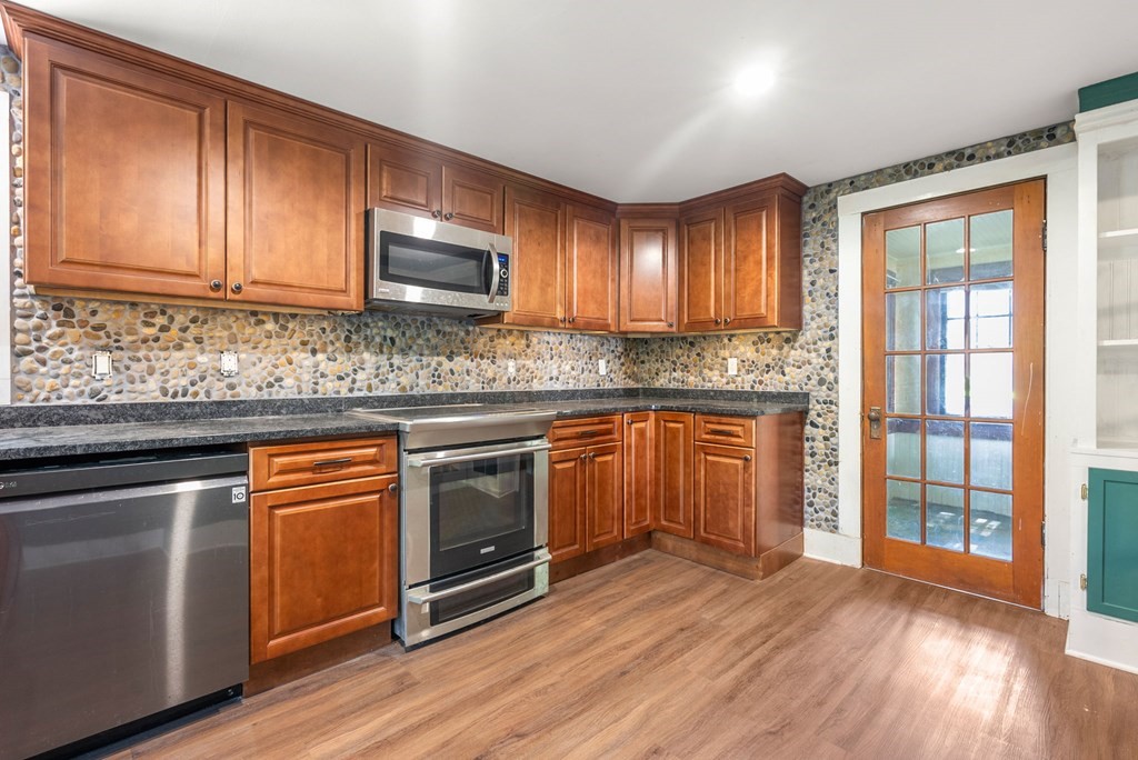 32 Undine Circle Springfield, MA 01109 - Photo 5 of 38 a kitchen with stainless steel appliances granite countertop wooden cabinets a sink a stove a refrigerator and island with wooden floors