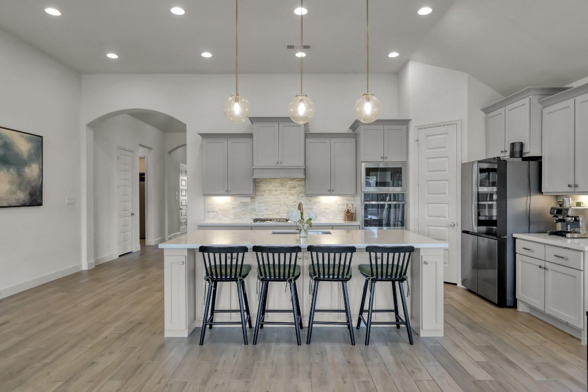 17801 Parnassum Path Conroe, TX 77302 - Photo 12 of 32 Kitchen lighting is thoughtfully layered with recessed, pendant, and under-cabinet fixtures for both function and ambiance.