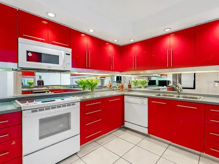 a kitchen with stainless steel appliances granite countertop a stove a microwave and red cabinets
